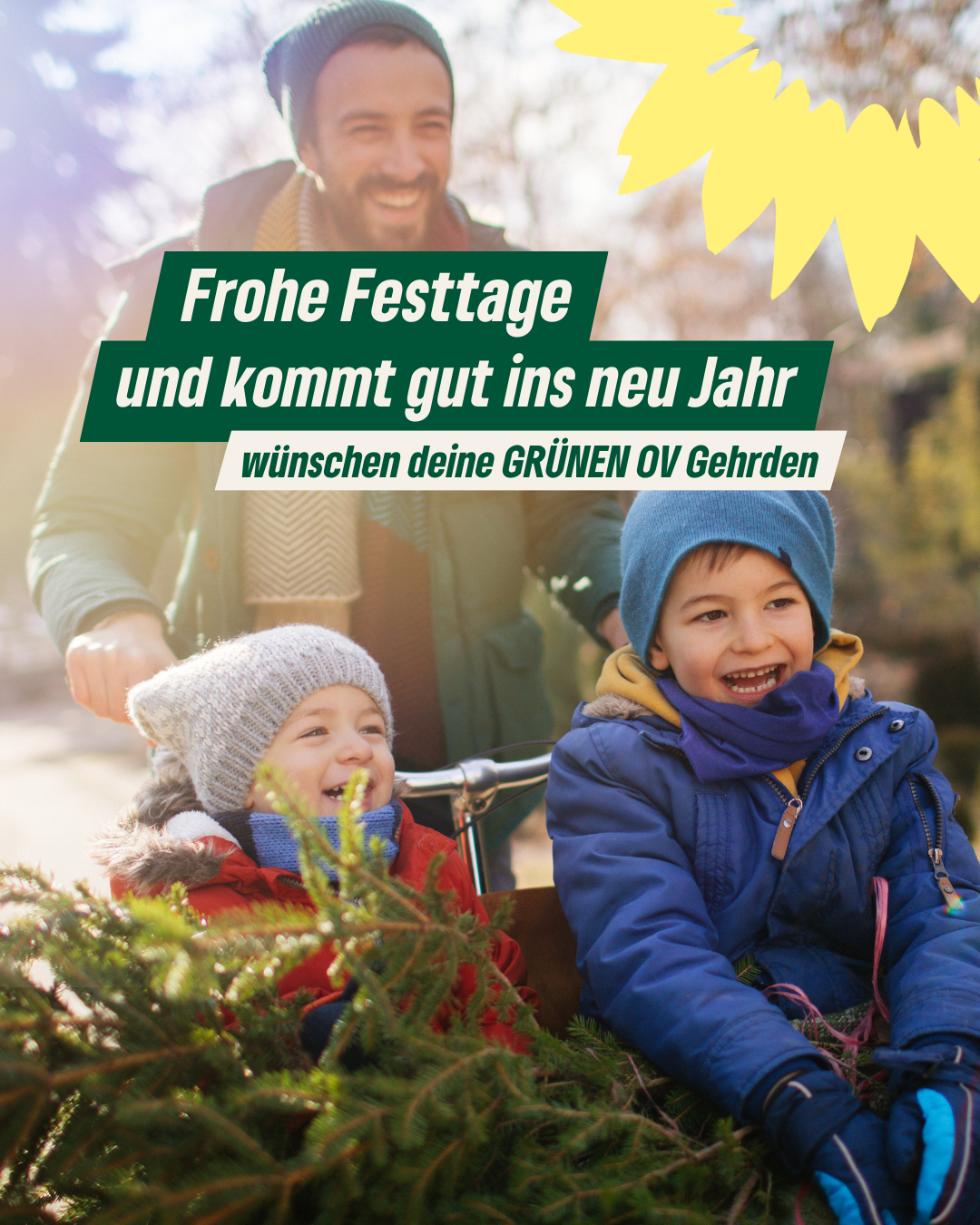 Ein helles, freundliches Foto im Freien, das einen lachenden Mann und zwei fröhliche Kinder zeigt, die einen Tannenbaum transportieren. Die Szene wirkt winterlich und herzlich. Im oberen rechten Eck ist das gelbe Sonnenblumen-Logo der Grünen angeschnitten. Zentrale Textboxen in Grün und Weiß tragen die Botschaft: „Frohe Festtage und kommt gut ins neu Jahr wünschen deine GRÜNEN OV Gehrden“.